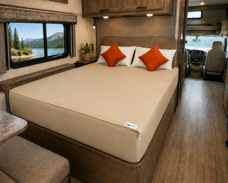 Beige Sleep Tight zipper fitted sheet made up on an RV bed, with a mountain lake visible through the window